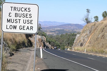 ‘Trucks and Buses Must Use Low Gear’ Stay in control on a steep descent Image
