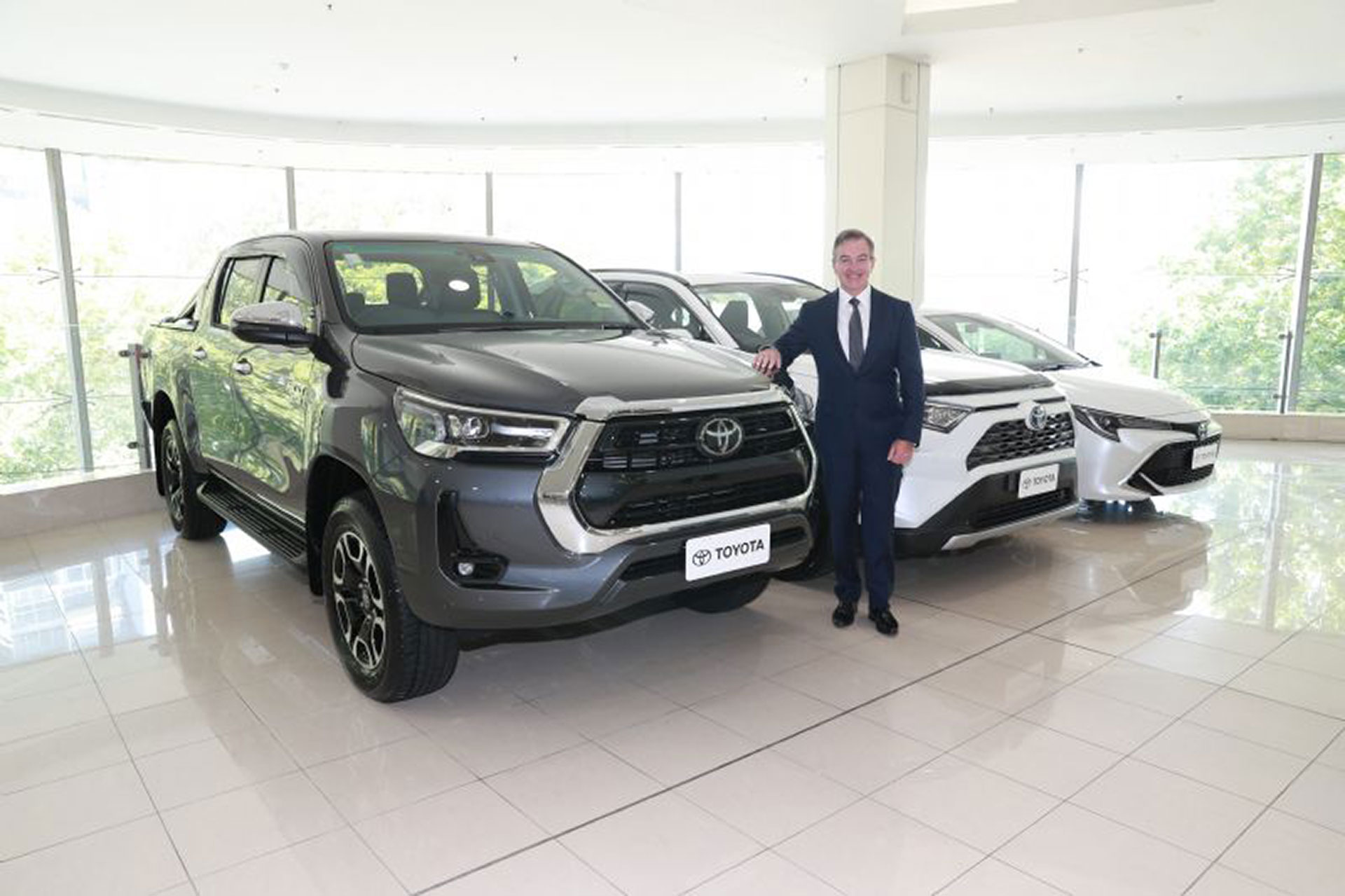 Toyota Australia President & CEO Matthew Callachor with Australia's top selling vehicle for 2021 Toyota HiLux, top selling SUV Toyota RAV4 (vehicle shown with optional extras) and top selling passenger vehicle Toyota Corolla.